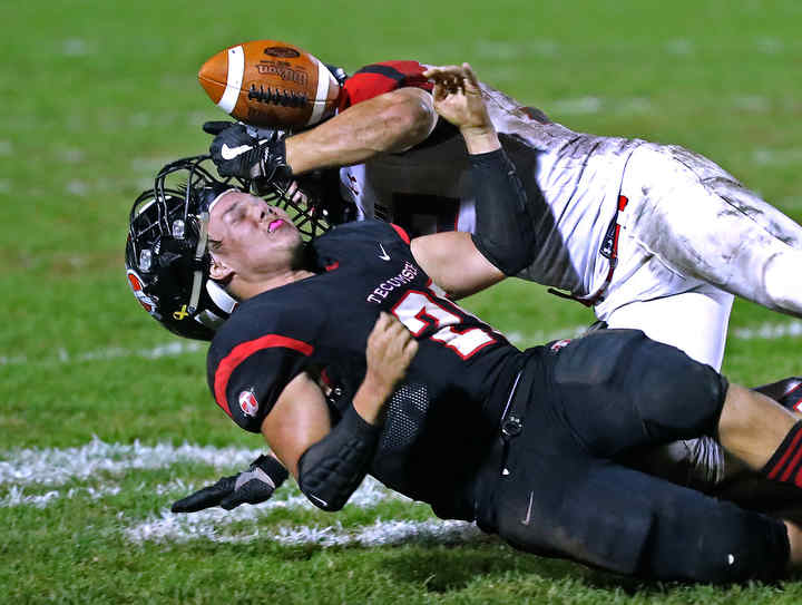 Bellefontaine's D.J. McDonald knocks the helmet off of Tecumseh's Wyatt Ferguson as he tackles him.  (Bill Lackey / Springfield News-Sun)